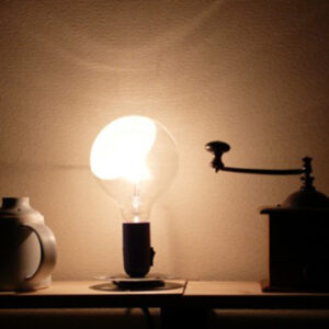 Imagen Lampadina Flos encendidad sobre una mesa